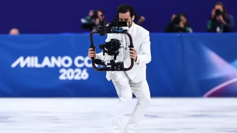 Cameraman Steals Spotlight at Winter Olympics by Skating Backwards in White Suit
