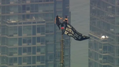 Two people reach Empire State Building top with banner — Empire State Building News