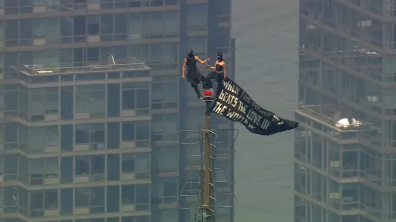 Two people reach Empire State Building top with banner — Empire State Building News