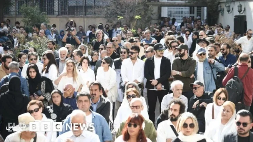 Pallbearers in White Carry Nasser Taghvai’s Coffin